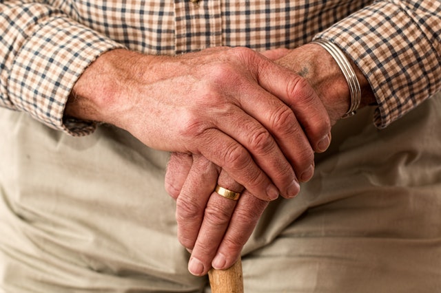 old man's hand on walking cane